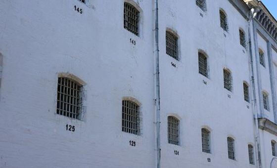 Exterior view of a white prison building in Ukraine with barred windows.